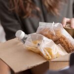 Person donating food to a box.