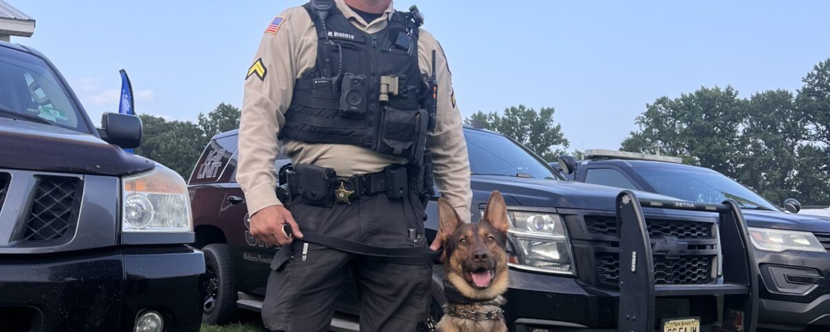 Police K9 with handler and patrol vehicle