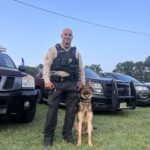 Police K9 with handler and patrol vehicle