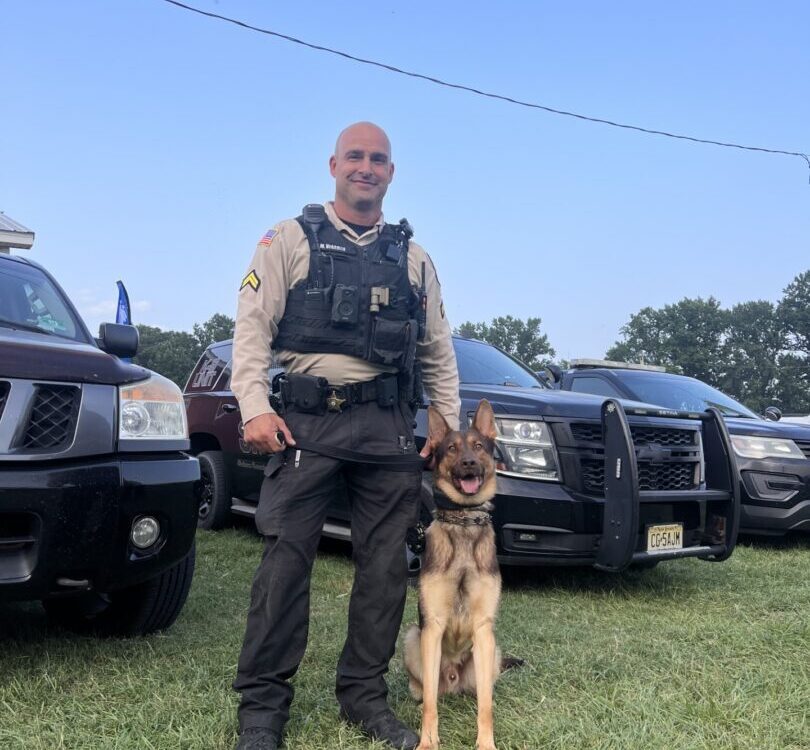 Police K9 with handler and patrol vehicle