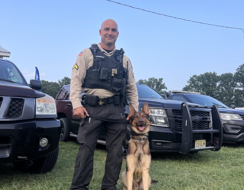 Police K9 with handler and patrol vehicle