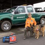 Search and Rescue K9 handler with SAR truck and equipment.
