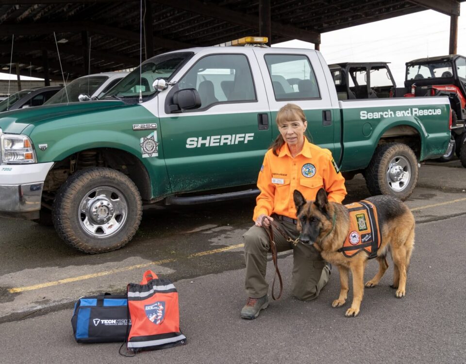 Search and Rescue K9 handler with SAR truck and equipment.