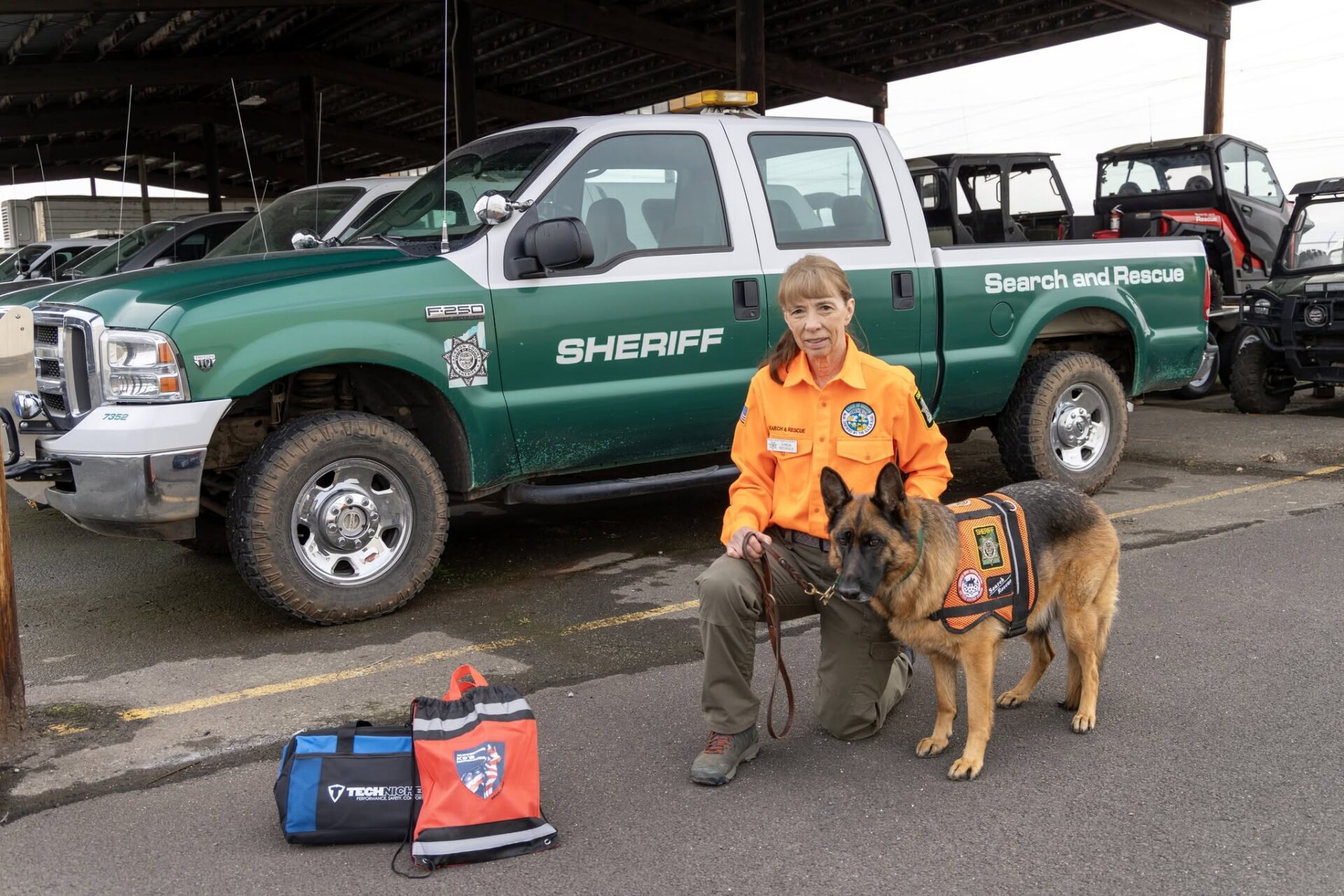 Search and Rescue K9 handler with SAR truck and equipment.